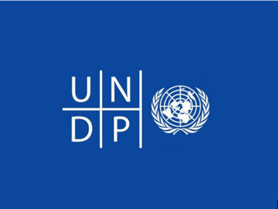 Логотип Програми розвитку ООН (ПРООН): білі літери UNDP та емблема ООН з картою світу в обрамленні лаврових гілок на синьому фоні.