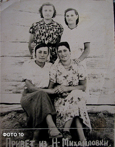 Архівне чорно-біле фото близько 1954 року: доярки колгоспу ім. Хрущова на молочно-товарній фермі в с. Новомихайлівка. Ганна Павлівна Еней (із дому Вайда) сидить першою ліворуч у нижньому ряду.