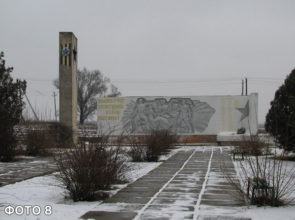  Загальний вид меморіального комплексу взимку: засніжена алея, що веде до пам'ятника жителям села, які загинули у 1941–1945 роках під час Другої світової війни, із стелою, барельєфом та високою вежею ліворуч 