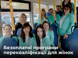 Група жінок-учасниць програми перекваліфікації у брендованих м'ятних кофтах посміхаються, сидячи в салоні пасажирського автобуса. У верхньому лівому кутку розміщено логотип «OnTrack Reskilling Ukraine», а внизу написано білий текст: «Безоплатні програми перекваліфікації для жінок».