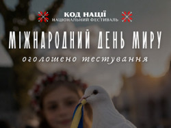 Дівчина у вишиванці та вінку тримає білого голуба зі стрічкою кольорів прапора України на тлі міської площі. Напис: «Код Нації. Національний фестиваль. Міжнародний день миру. Долучайся до тестування! peace.kod-natsii.com»