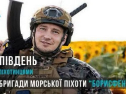 Військовослужбовець морської піхоти в шоломі та бронежилеті з автоматом на плечі посміхається на тлі соняшникового поля. На зображенні напис «Борони Південь з морськими піхотинцями» і емблема бригади «Борисфен».